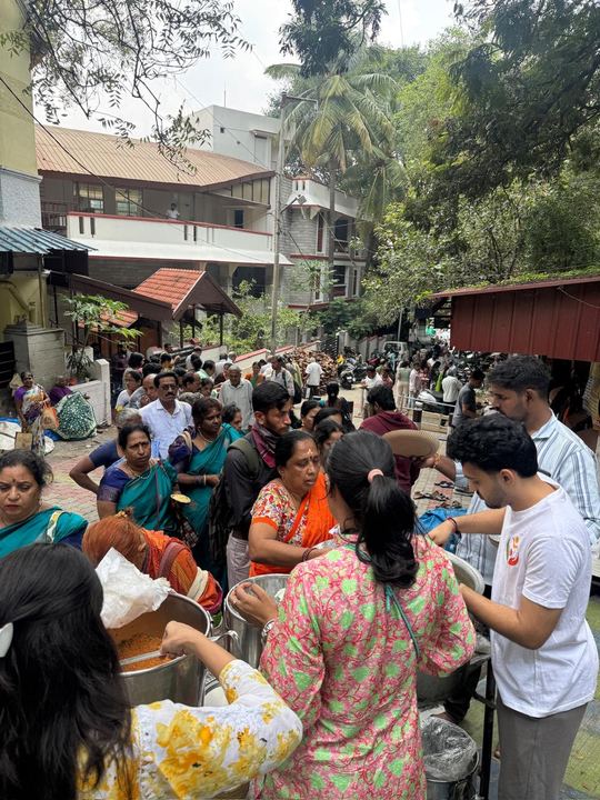 Volunteers filling plates at the head of the queue on the temple approach road