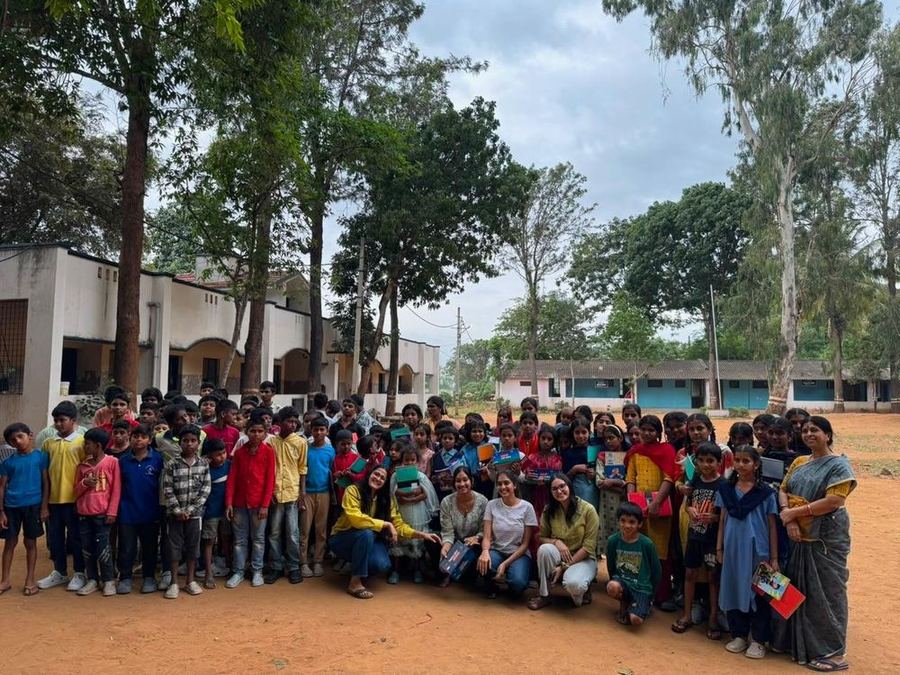 Volunteers with the children of the gurukul, who are holding their new books